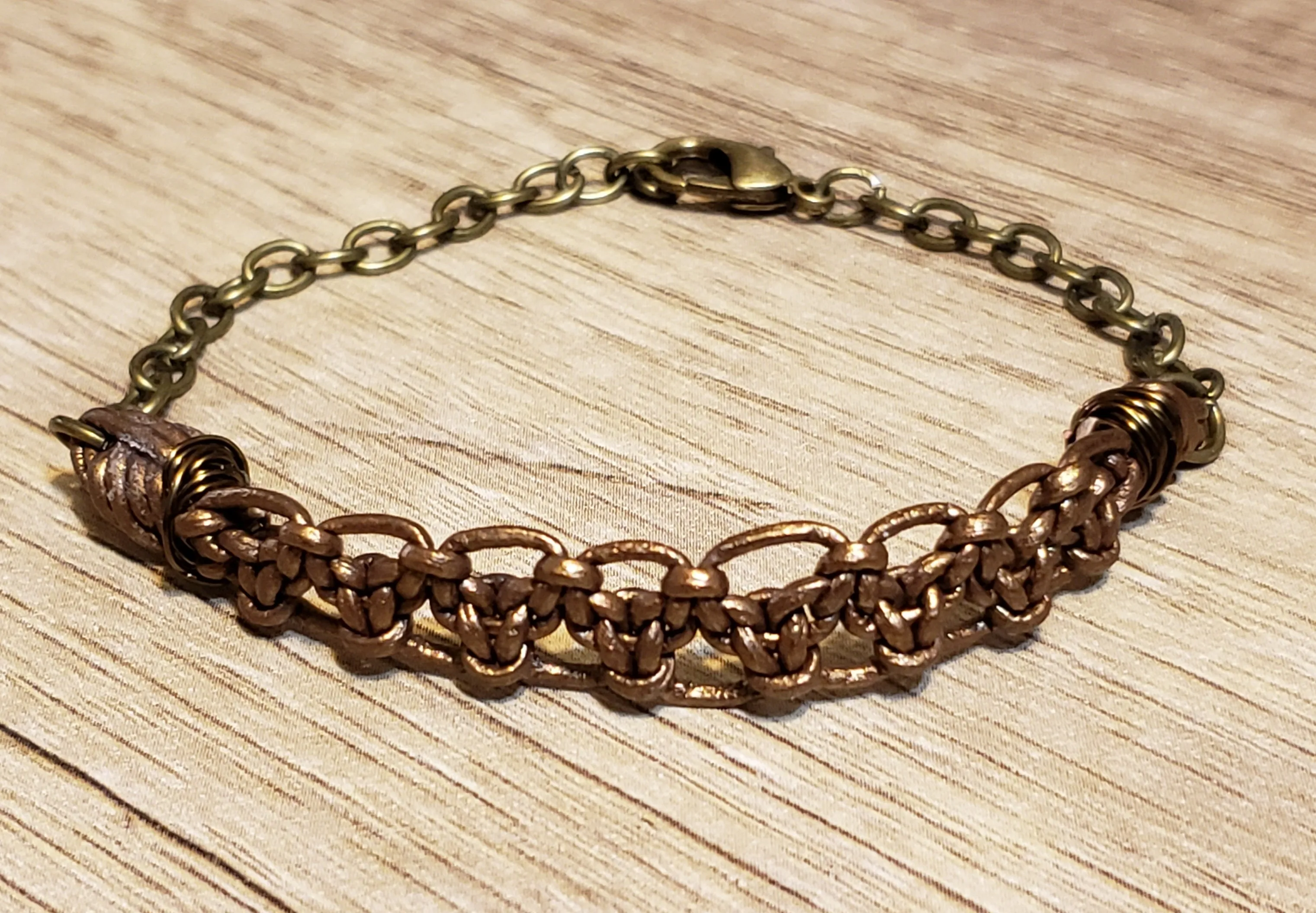 Metallic Bronze Leather Bracelet & Gold Tone Stainless Steel Chain, Adjustable up to 8" with Lobster Claw Clasp.
 